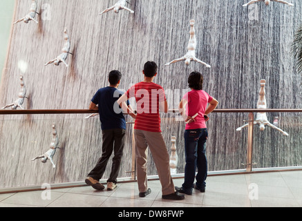 Tre locali di ragazzi adolescenti guardando la cascata nel centro commerciale di Dubai, Dubai, Emirati Arabi Uniti, Emirati Arabi Uniti Medio Oriente Foto Stock