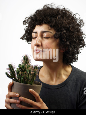 Donna odora un cactus Foto Stock