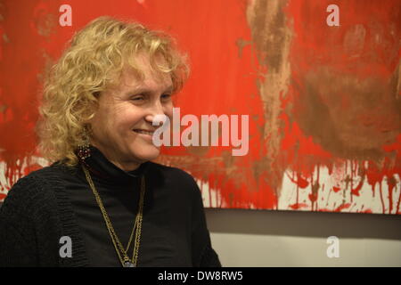 Huntington, New York, Stati Uniti - 1 Marzo 2014 - Presso il ricevimento di apertura '3 folle e sfrenata degli artisti in galleria FotoFoto, una donna sorrisi Visitatore alla mostra " Red & White dipinti e fotografie - El Vocio esistenziale dall' artista Barry Feuerstein. Foto Stock