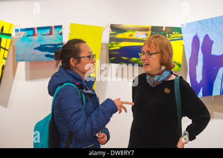 Huntington, New York, Stati Uniti - 1 Marzo 2014 - a destra la moglie di artista Thom O'Connor discute il suo mostra 'appesi ad asciugare' con un visitatore al ricevimento di apertura '3 Wild & Crazy artisti' alla Galleria FotoFoto. Foto Stock