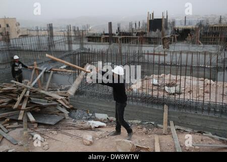 Gerusalemme, Gerusalemme est. Israele ha iniziato la costruzione di 2,534 unità abitative negli insediamenti durante il 2013, un 123 percento di aumento a partire dal 2012. 3 Mar 2014. File foto prese su Ott. 30, 2013 mostra costruzione palestinese lavoratori su un sito di costruzione nell'insediamento ebraico di Ramat Shlomo, nei pressi del quartiere arabo di Beit Hanina, Gerusalemme est. Israele ha iniziato la costruzione di 2,534 unità abitative negli insediamenti durante il 2013, un 123 percento di aumento a partire dal 2012, l'Ufficio centrale di statistica, pubblicata il 3 marzo 2014. Credito: Muammar Awad/Xinhua/Alamy Live News Foto Stock