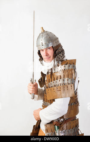 Il guerriero medievale uomo che indossa in antiche armor con la spada Foto Stock