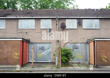 Abbandonata la scatola terrazzati con serrande metalliche, Salford, Regno Unito Foto Stock