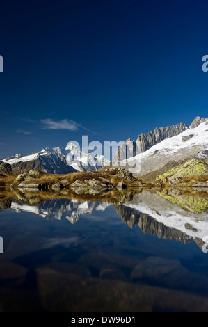 Lago di montagna sulla montagna Bettmerhorn, patrimonio Unesco, di fronte a picchi dell' Oberland Bernese Foto Stock