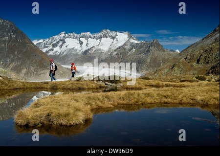 Lago di montagna e gli escursionisti in montagna Bettmerhorn, nella parte anteriore dei picchi del Bernese Oberland e il ghiacciaio di Aletsch, UNESCO Foto Stock