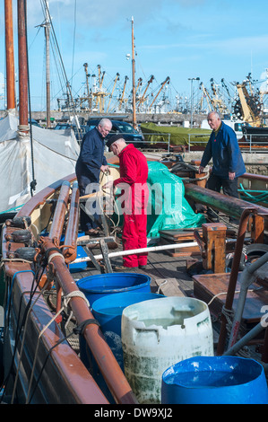 I marinai riparazione vecchia barca a brixham devon,,flotta peschereccia ormeggiata al Porto di Brixham,l'architettura,Brixham,Edificio ExteriorBuilt Foto Stock