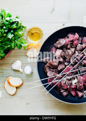 Gli spiedini di carne e cottura in padella Foto Stock