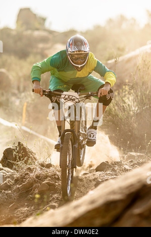 Maschio di mountain biker racing su pista polverosa, Fontana, in California, Stati Uniti d'America Foto Stock