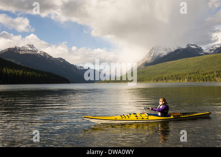 Kayak femminile su Santa Maria Lake, il Parco Nazionale di Glacier, Montana, USA Foto Stock