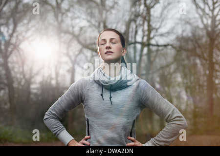 Giovane donna appoggiata con gli occhi chiusi Foto Stock