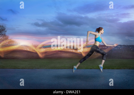 Giovane donna in esecuzione con percorsi di luce Foto Stock