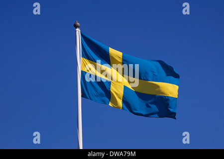 Bandiera nazionale della Svezia sbattimenti nel vento contro il cielo blu Foto Stock