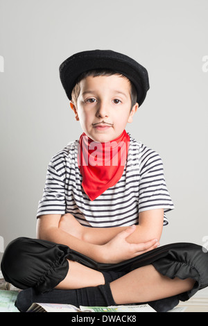 Bambino vestito come un ladro con una striata top,black hat e mal disegnato i baffi Foto Stock