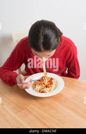 Ragazza adolescente mangiare pasta Foto Stock