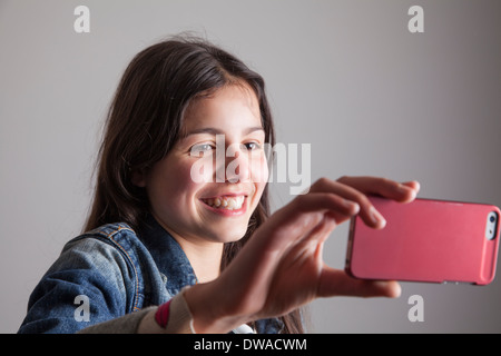 Ragazza adolescente facendo una chiamata video sul suo telefono cellulare Foto Stock