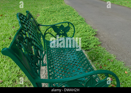 Banco di verde nel parco su erba vicino al marciapiede Foto Stock