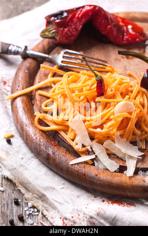 Arancione spaghett pomodoro (tagliolini al pomodoro) con grigliate di paprika rossa e formaggio Parmigiano servito sul tagliere di legno Foto Stock