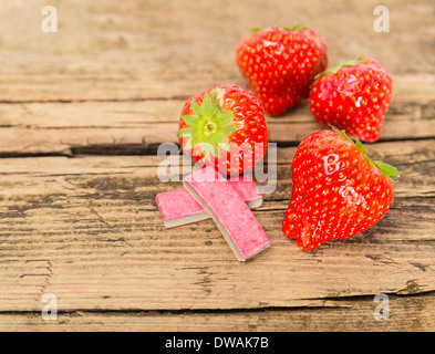 Fragola chewing gum su sfondo di legno Foto Stock