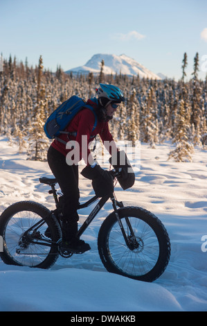 Foto della persona che guida fat tire snow bike sul speedway trail, Campbell sentieri, Anchorage, vista laterale rivolto verso destra Foto Stock