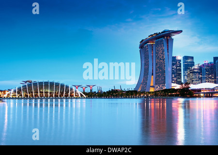 Giardini dalla baia e le sue serre e il Marina Bay Sands Hotel dopo il tramonto dalla Bay East Garden Foto Stock