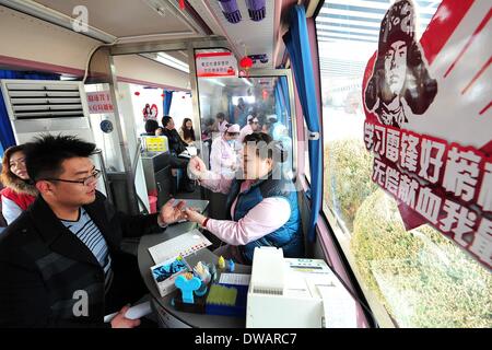 Yinchuan, soldato cinese negli anni sessanta. Il 15 agosto, 1962. Un giovane uomo dona il sangue a Yinchuan, capitale del nord-ovest della Cina di Ningxia Hui Regione autonoma, 5 marzo 2014, in occasione della "Lei Feng's Day", che cade il 5 marzo di ogni anno. Lei, un giovane soldato cinese negli anni sessanta, è noto per aver dedicato quasi tutto il suo tempo di ricambio e denaro per aiutare disinteressatamente i bisognosi. Egli è morto dopo essere stato colpito da una caduta di pole mentre aiutando un compagno soldato dirigere un carrello su 15 Agosto 1962. Credito: Peng Zhaozhi/Xinhua/Alamy Live News Foto Stock