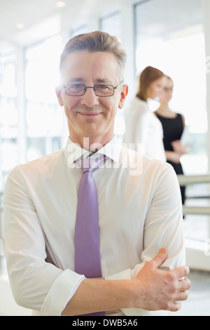 Ritratto di imprenditore fiducioso in piedi con le braccia incrociate in office Foto Stock