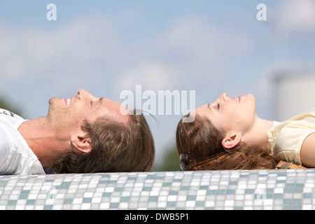 Vista laterale del giovane rilassante sulla parete a mosaico Foto Stock