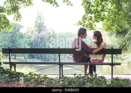 Romantico coppia giovane seduto su una panchina nel parco sul lago di garda Foto Stock