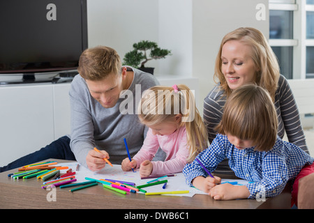 I genitori con bambini disegno insieme a casa Foto Stock