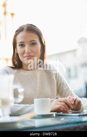 Ritratto di giovane donna al cafè sul marciapiede Foto Stock
