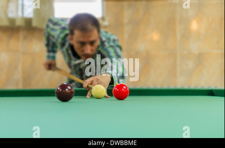 Giovane uomo giocare biliardo. Sala biliardo Foto Stock