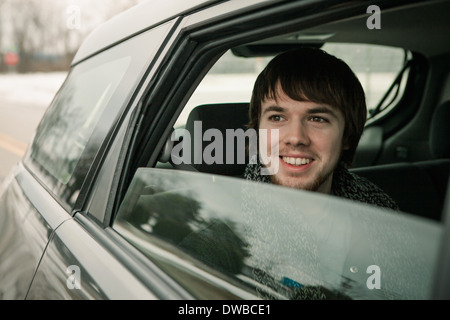 Giovane uomo guardando fuori della finestra auto Foto Stock