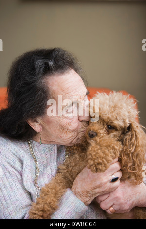 Senior donna baciare cane Foto Stock