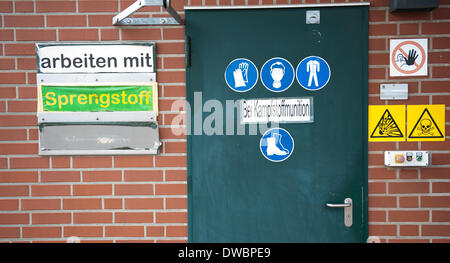 Munster, Germania. 5 Mar 2014. Numerose etichette e cartelli di avvertimento etichetta una porta ad un impianto di GEKA, la proprietà del governo azienda specializzata nello smaltimento delle armi chimiche, nei locali dell'azienda in Munster, Germania, 5 marzo 2014. La GEKA (Gesellschaft zur Entsorgung von chemischen Kampfstoffen und Ruestungsaltlasten/GEKA) è la sola azienda in Germania che è coinvolto nello smaltimento delle armi chimiche da parte della Siria. Foto: Philipp Schulze/dpa/Alamy Live News Foto Stock