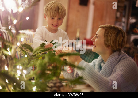 Madre e figlio decorare albero di natale Foto Stock