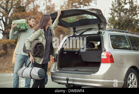 La donna la chiusura bagagliaio della vettura mentre il campeggio con uomo Foto Stock