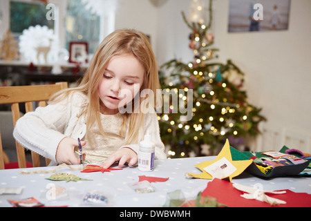 Giovane ragazza il taglio del documento in preparazione al Natale Foto Stock