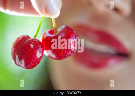 Donna che mantiene fino le ciliegie Foto Stock