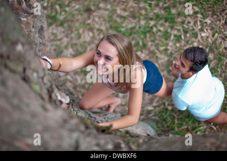 Ragazzo ragazza di sollevamento fino tree Foto Stock