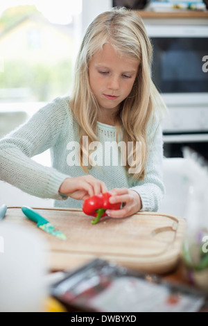 Ragazza tagliare il peperone in cucina Foto Stock