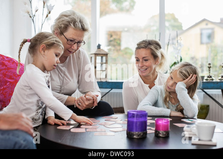 Tre femmine di generazione di carta da gioco gioco di puzzle a casa Foto Stock