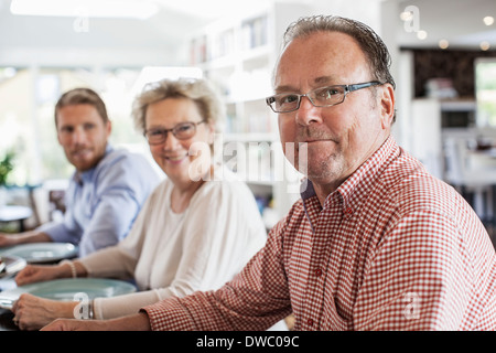 Ritratto di due generazioni la famiglia seduti al tavolo da pranzo Foto Stock