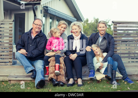 Ritratto di felice multi-generazione famiglia seduti insieme in cantiere Foto Stock