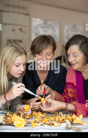 Tre femmine di generazione di pulizia fungo chanterelle insieme a casa Foto Stock