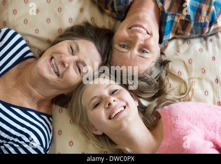 Ritratto di overhead di felice tre femmine generazione giacente sul letto Foto Stock