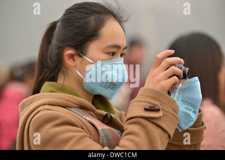 Una ragazza indossa una maschera in piazza Tiananmen a Pechino, 26 Febbraio 2014 Foto Stock