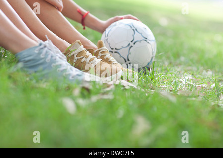 Ritagliato colpo di giovani donne gambe e pallone da calcio Foto Stock