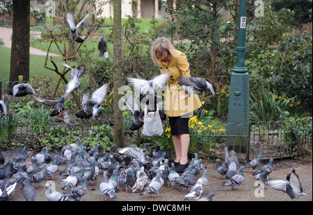 Donna alimentazione dei piccioni in Pavilion Gardens Brighton Foto Stock