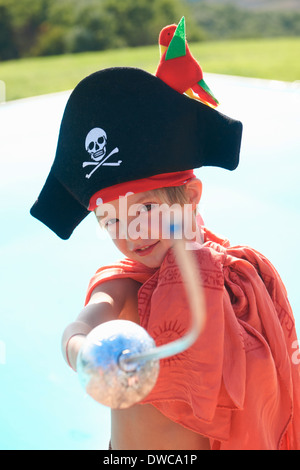 Ritratto di ragazzo in pirati hat, puntando spada giocattolo Foto Stock