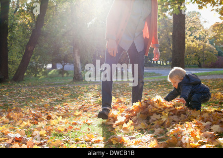Padre e figlio giocare con foglie di autunno Foto Stock